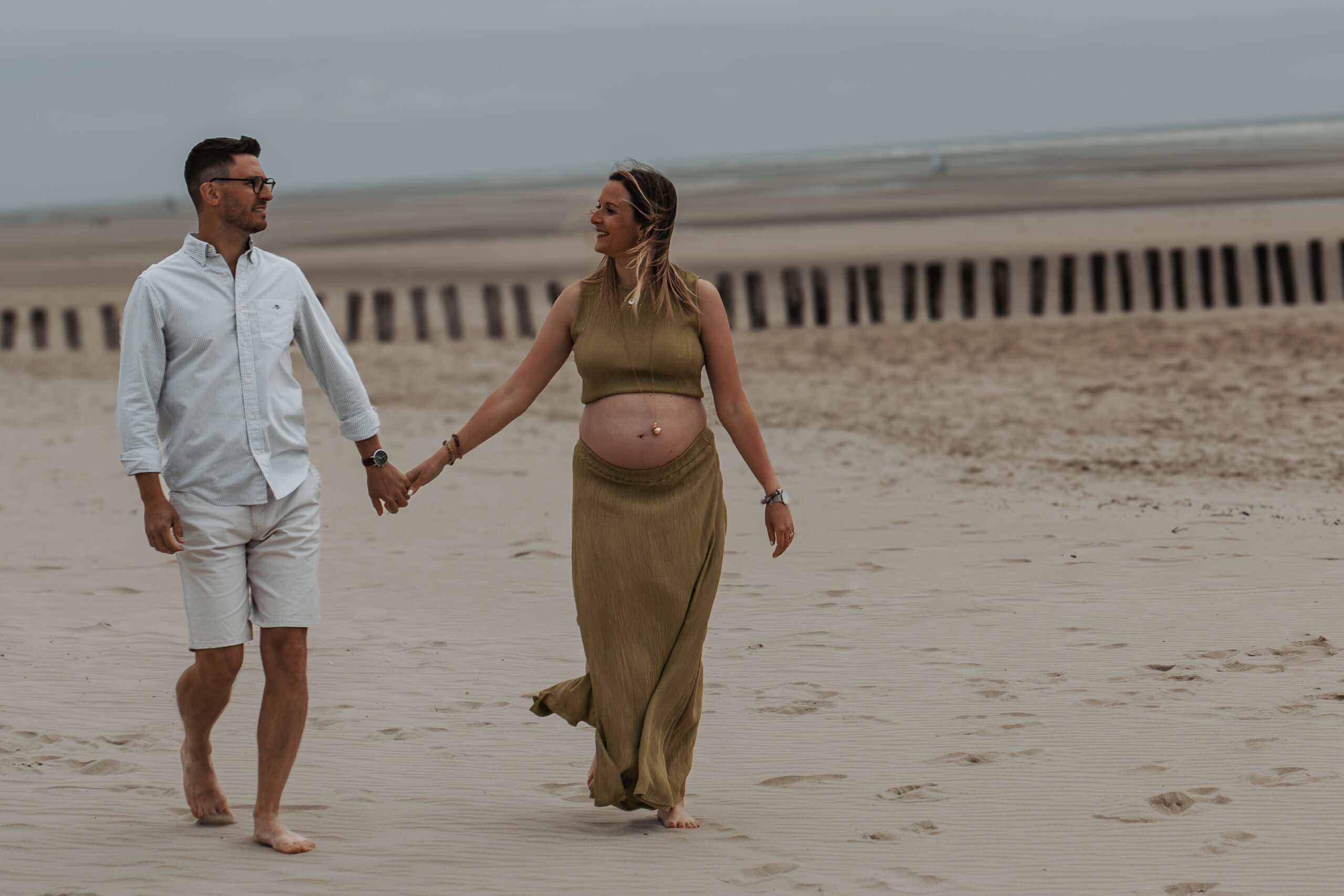 Couple marchant main dans la main sur la plage